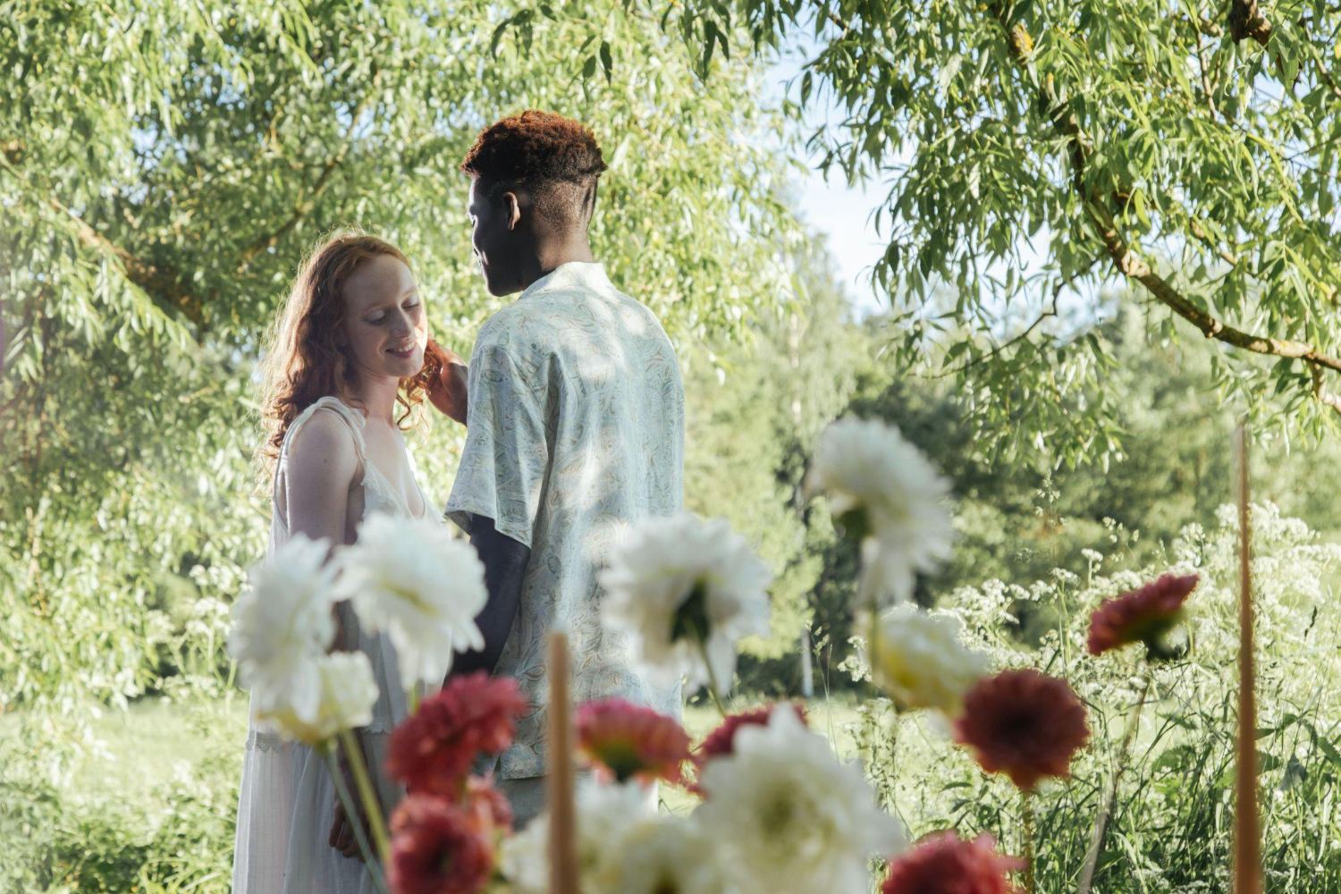 Two lovers behind a spray of garden flowers