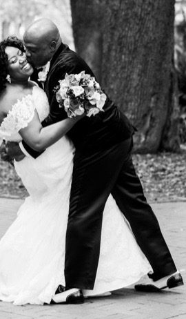 A couple in a passionate dip, the groom kissing the bride, in black and white