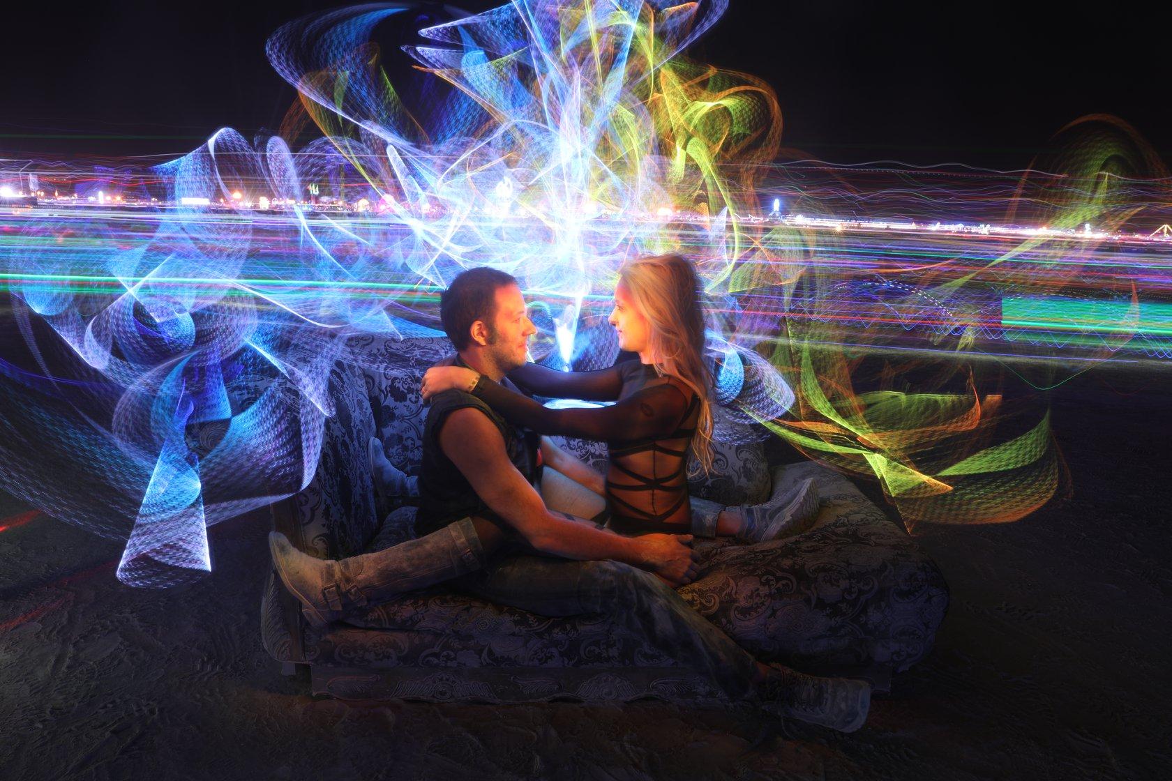 Light painting around two figures on the playa